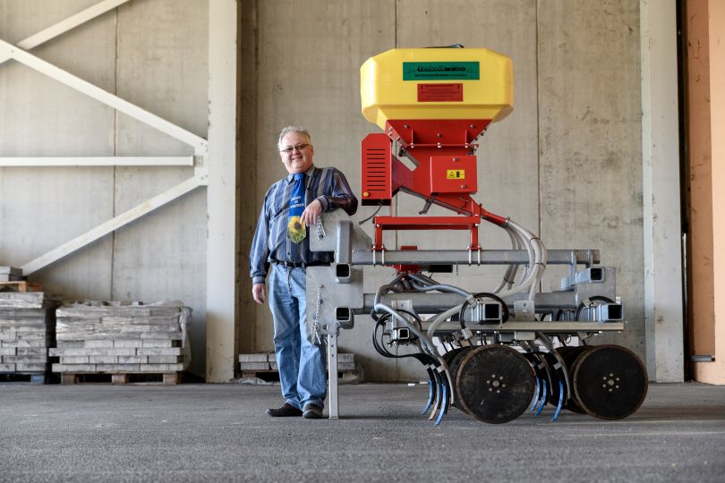 Mann steht vor Sämaschine