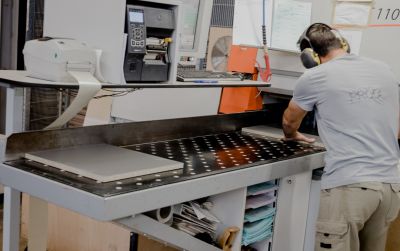 Arbeiter mit Gehörschutz bearbeitet Pressspanplatte