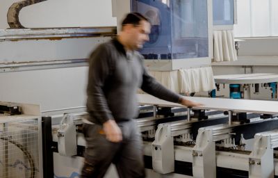 Mann, verschwommen, greift im Gehen auf Maschine.