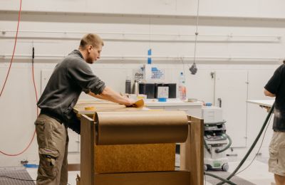 Arbeiter schleift mit Schleifpapier