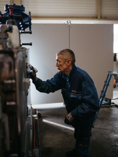 Arbeiter poliert Maschine