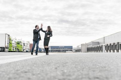 Mann und Frau klatschen vor LKWs ein