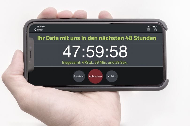 © Niki Schreinlechner Hand mit Handy. Auf dem Display steht: "Ihr Date mit uns in den nächsten 48 Stunden. 47:59:58
