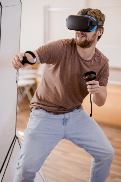 Mann mit Virtual-Reality-Brille und Joysticks in den Händen.