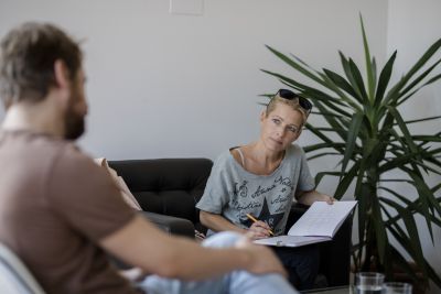 Sigrid Gaisch-Faustmann sitzt in Interviewsituation und schreibt in Block.