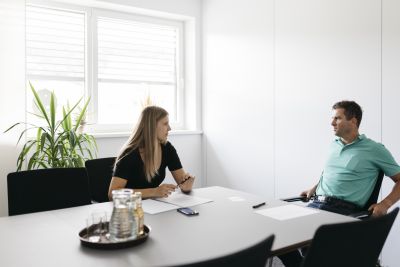 Sigrid Merth und Florian Hampel sitzen in Interviewsituation an einem Tisch