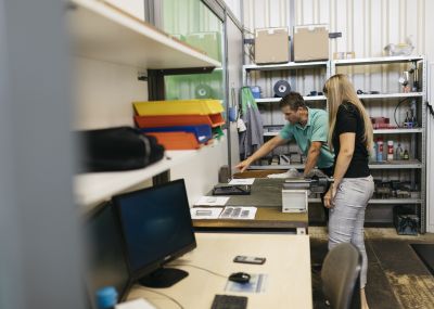 Florian Hampel zeigt Sigrid Merth etwas auf einer Werkbank