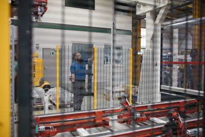 Mann setzt Metallgitter in Maschine ein