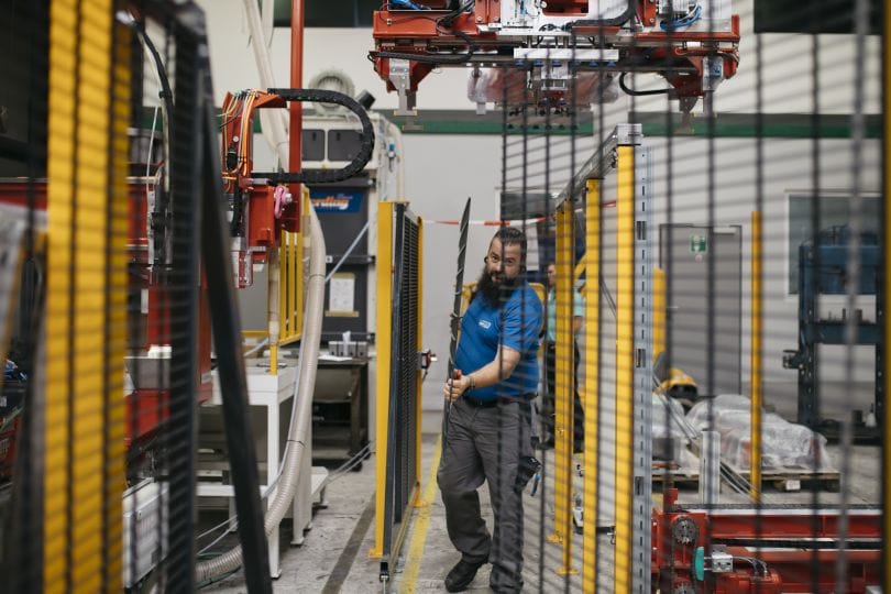 © Christine Wiener
Mann trägt in Produktionshalle Metallgitter