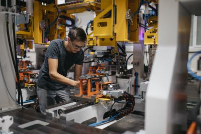 Mann mit Brille und schwarzem Shirt arbeitet an Maschine