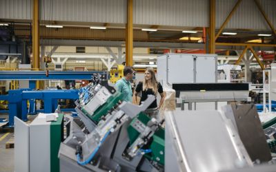 Florian Hampel und Sigrid Merth in einer Produktionshalle, im Vordergrund Maschinenteile