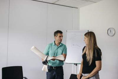 Florian Hampel hält vor Flipchart Propeller in der Hand, neben ihm Sigrid Merth
