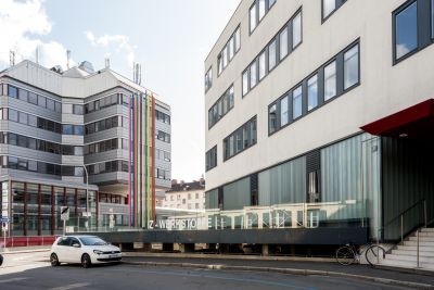 Zwei moderne Gebäude, bunte Stäbe, Schriftzug IZ-WERKSTOFFE