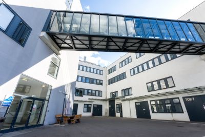 Moderne Gebäude in weiß, mit Glas-Stahl Übergang verbunden, nummerierte Tore