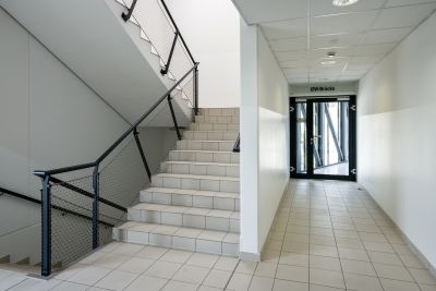 Stiegenhaus in Bürogebäude, Tür mit Schild "IZW-Brücke"