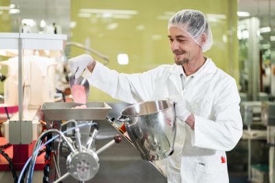 Pharmazeut füllt Kapseln in Maschine
