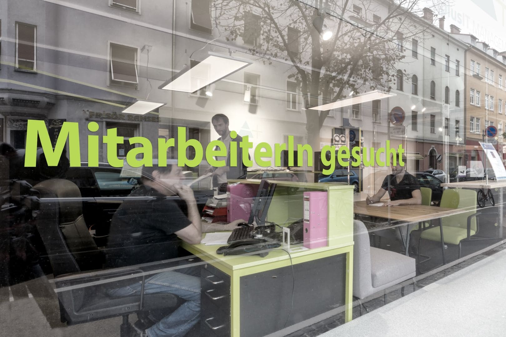 Büro durch Glasscheibe, Aufdruck MitarbeiterIn gesucht.